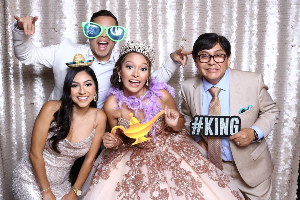 Quinceañera with family posing with props in Dallas photo booth