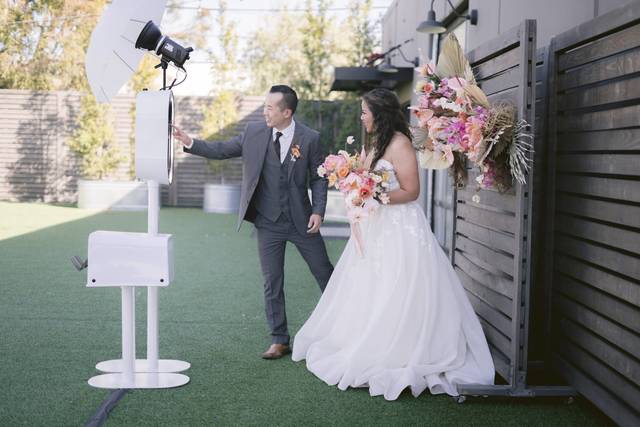 Bride and groom using photo booth at outdoor Dallas wedding