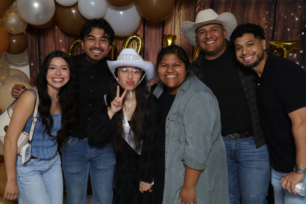 Bride having fun with family at a Dallas Photo Booth Collab event with cowboy-themed decor.