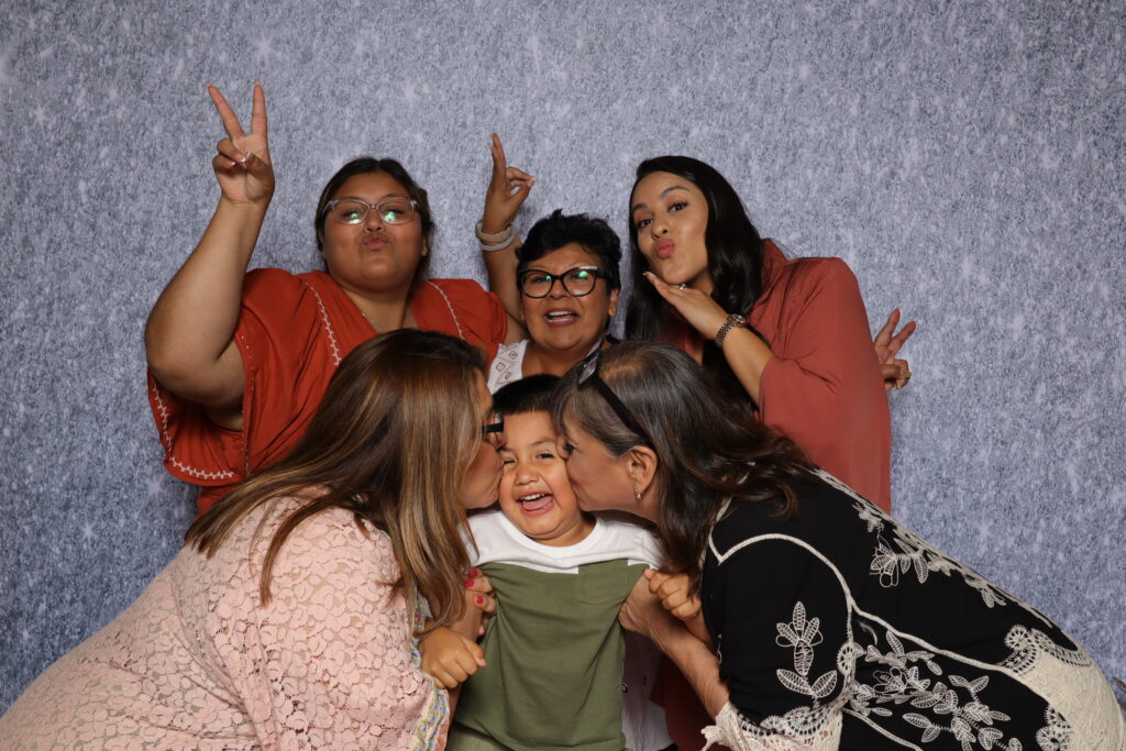 Group of friends laughing and capturing memories at a Dallas photo booth collab party.
